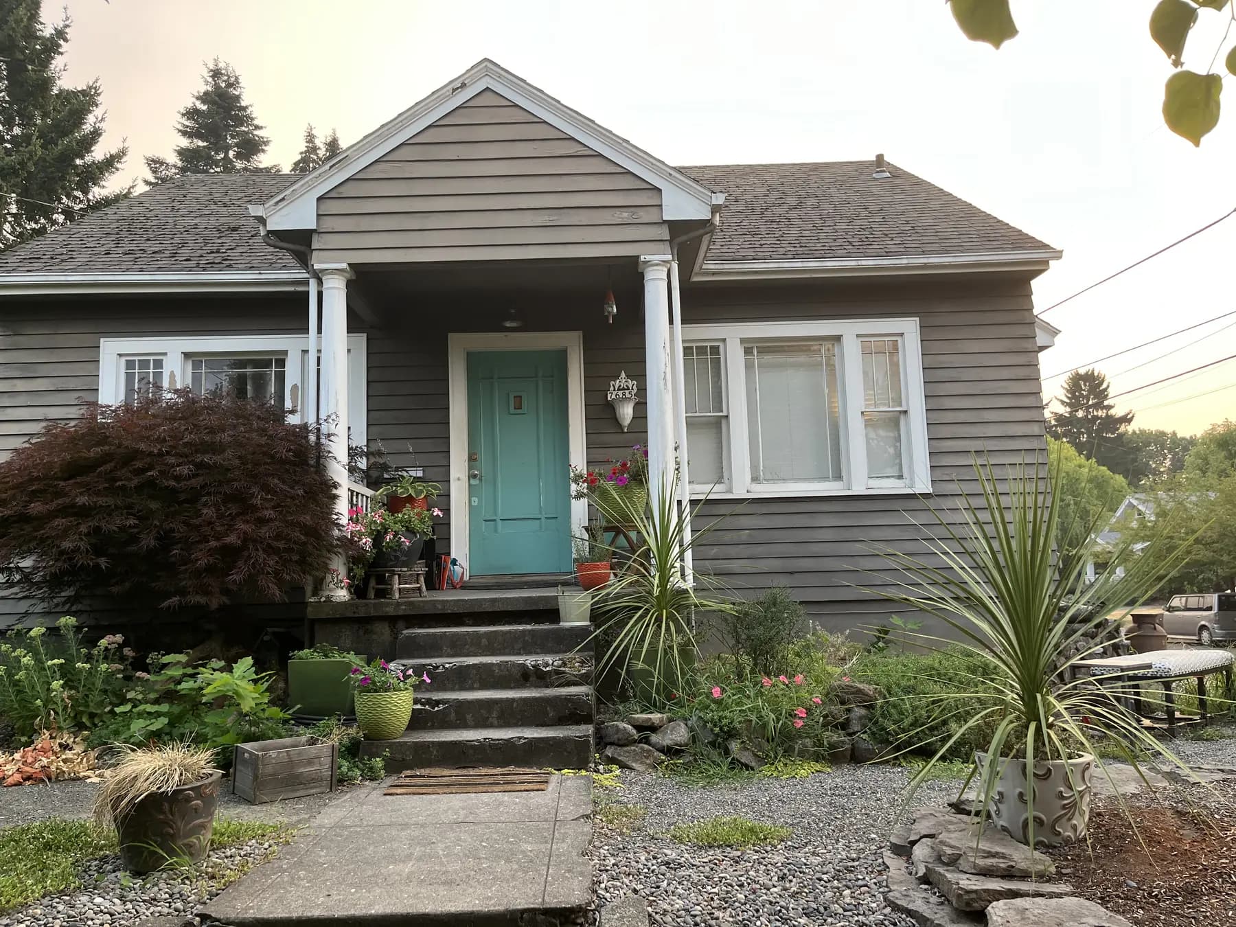 Front entry before restoration with faded siding and worn white trim.